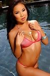 Wet round boobed asian babe Thuy Li poses in revealing pink bikini in the sun