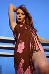 Slim redhead Marie McCray strips down to her bikini and shows her private parts on balcony