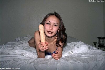 Insignificant Japanese adolescent Tina playing with heavy sex-toy on daybed in high heels