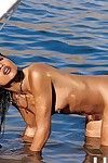 bronzo pelato orientale lily thai prende off Il suo Bikini e in piedi nudo in il mare